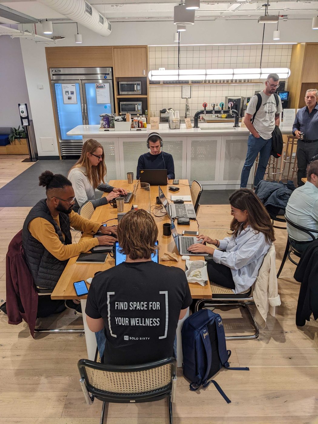 The team working together at a shared table in the YJCollective days